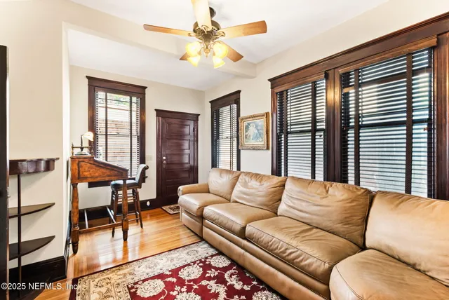 a view of a dining room and livingroom with furniture wooden floor a chandelier