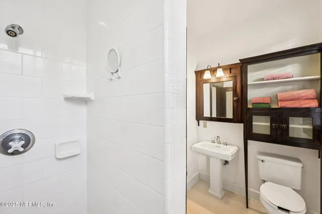 a white toilet sitting next to a white tub