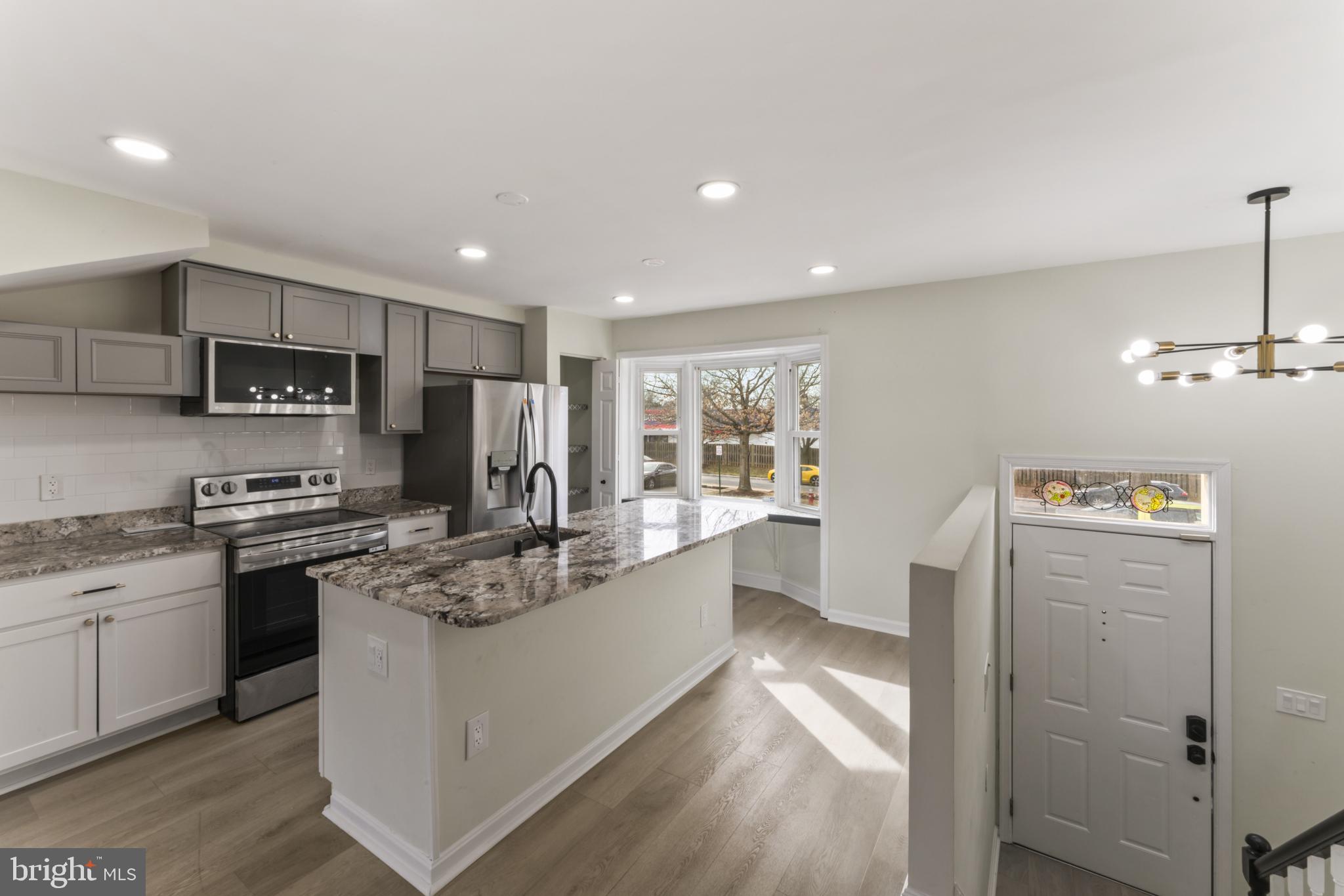 8213 Roxbury Drive Alexandria, VA 22309 - Photo 17 of 32 a kitchen with stainless steel appliances granite countertop a refrigerator a sink dishwasher a stove and white cabinets with wooden floor