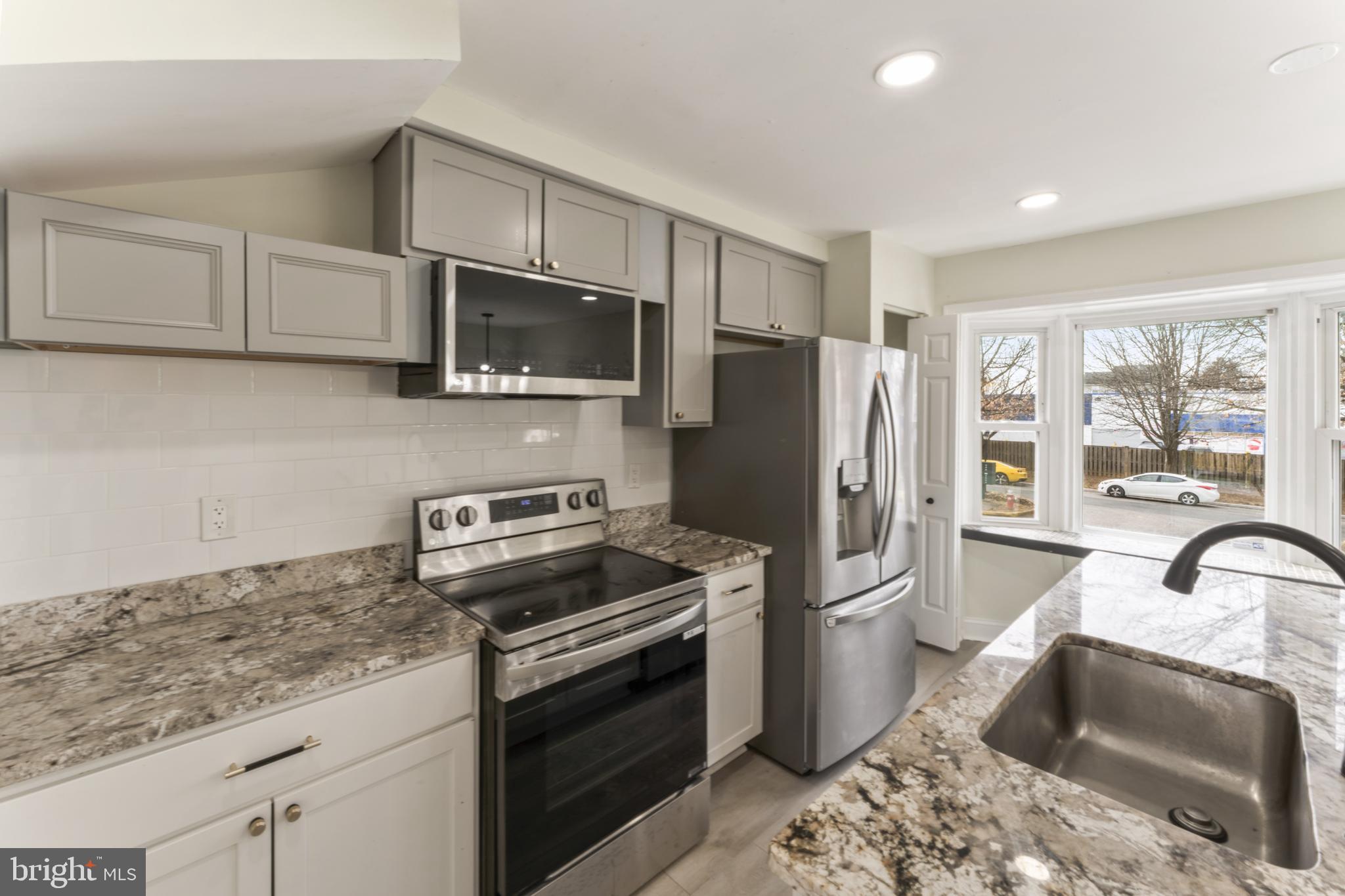 8213 Roxbury Drive Alexandria, VA 22309 - Photo 19 of 32 a kitchen with stainless steel appliances granite countertop a refrigerator stove and sink
