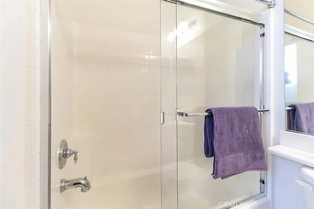 a view of a patio with dining table and chairs under an umbrella with large trees