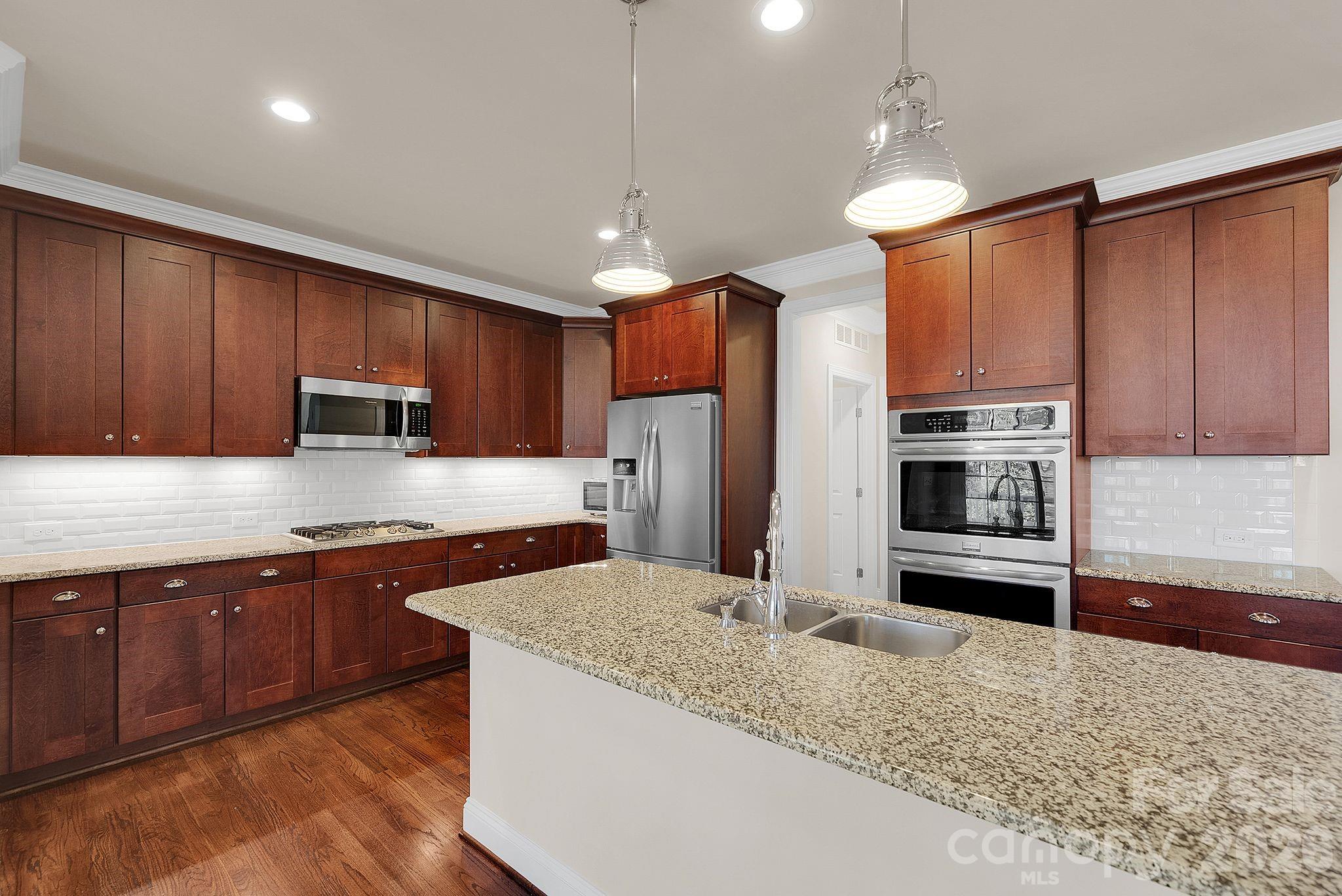 535 Brightleaf Place Northwest Concord, NC 28027 - Photo 13 of 48 a kitchen with stainless steel appliances granite countertop a sink refrigerator and microwave