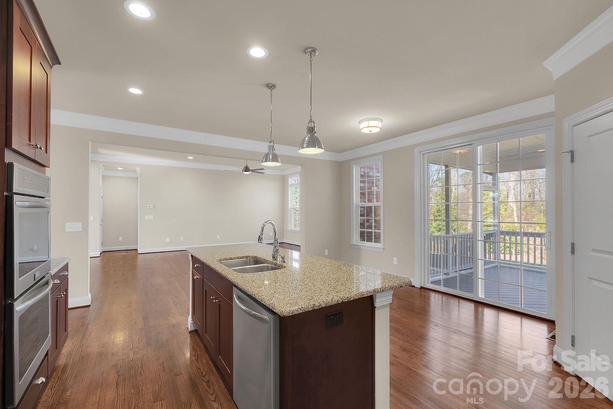 535 Brightleaf Place Northwest Concord, NC 28027 - Photo 14 of 48 a kitchen with a sink chandelier and wooden floor