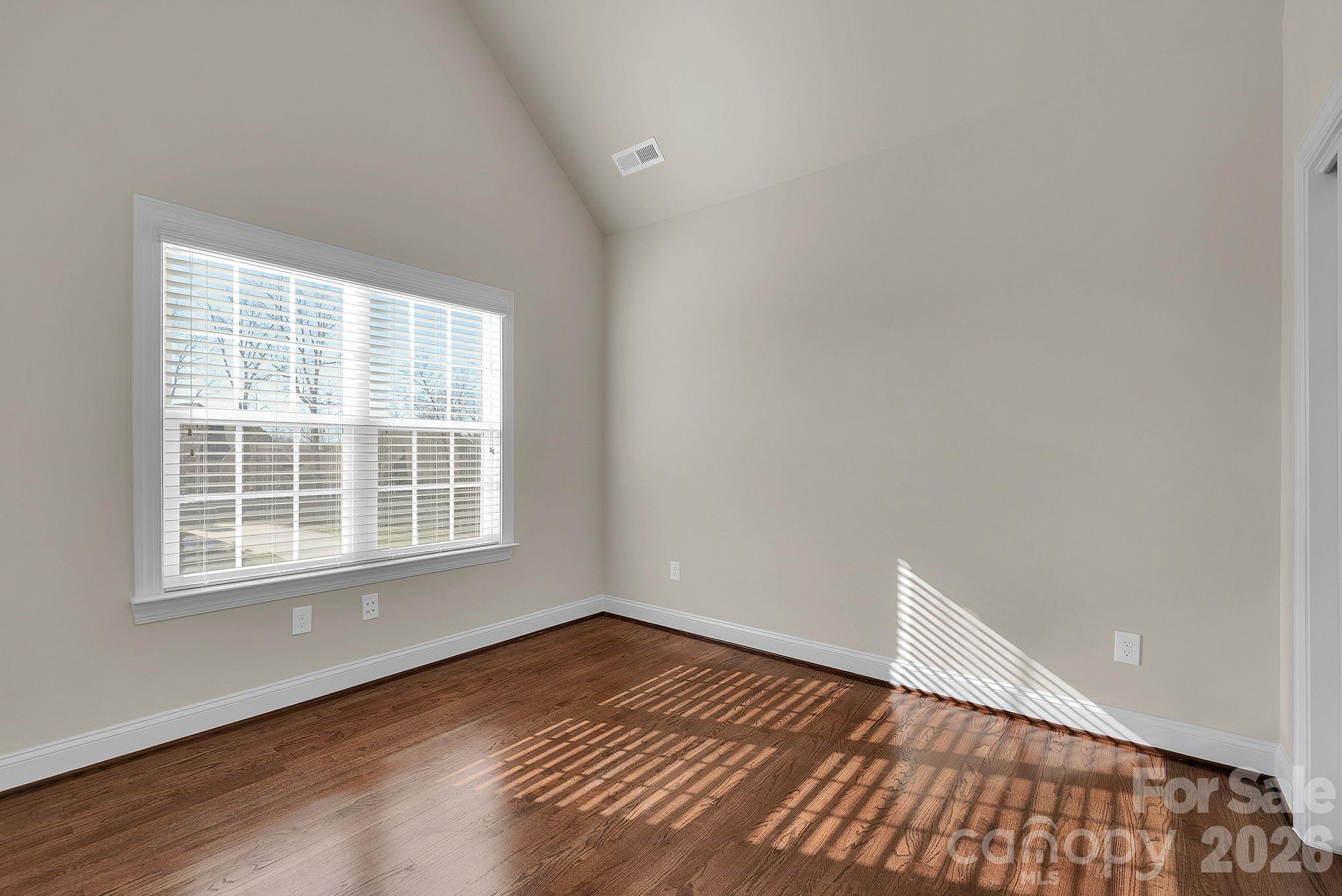 535 Brightleaf Place Northwest Concord, NC 28027 - Photo 26 of 48 an empty room with wooden floor and windows