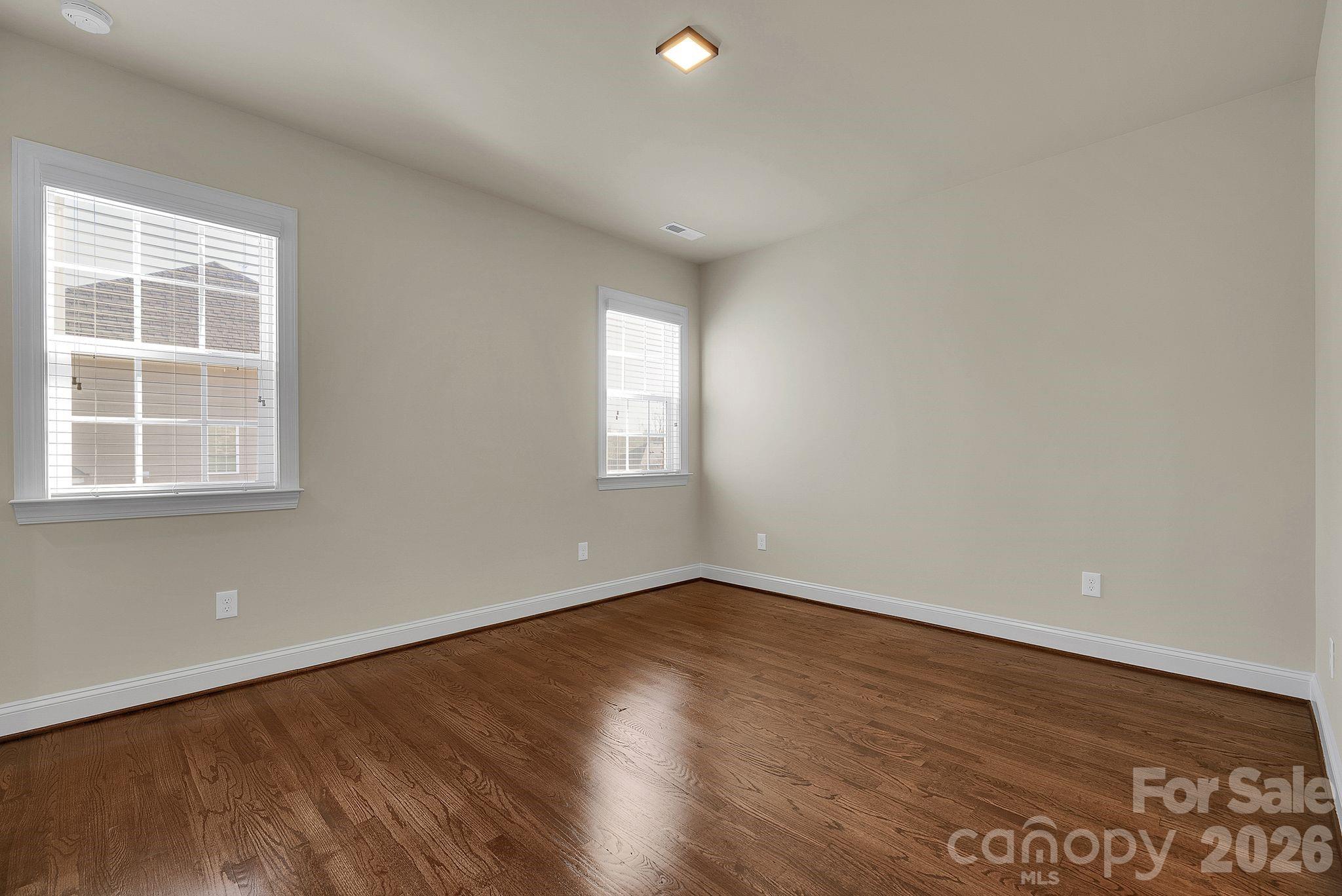 535 Brightleaf Place Northwest Concord, NC 28027 - Photo 29 of 48 an empty room with wooden floor and windows