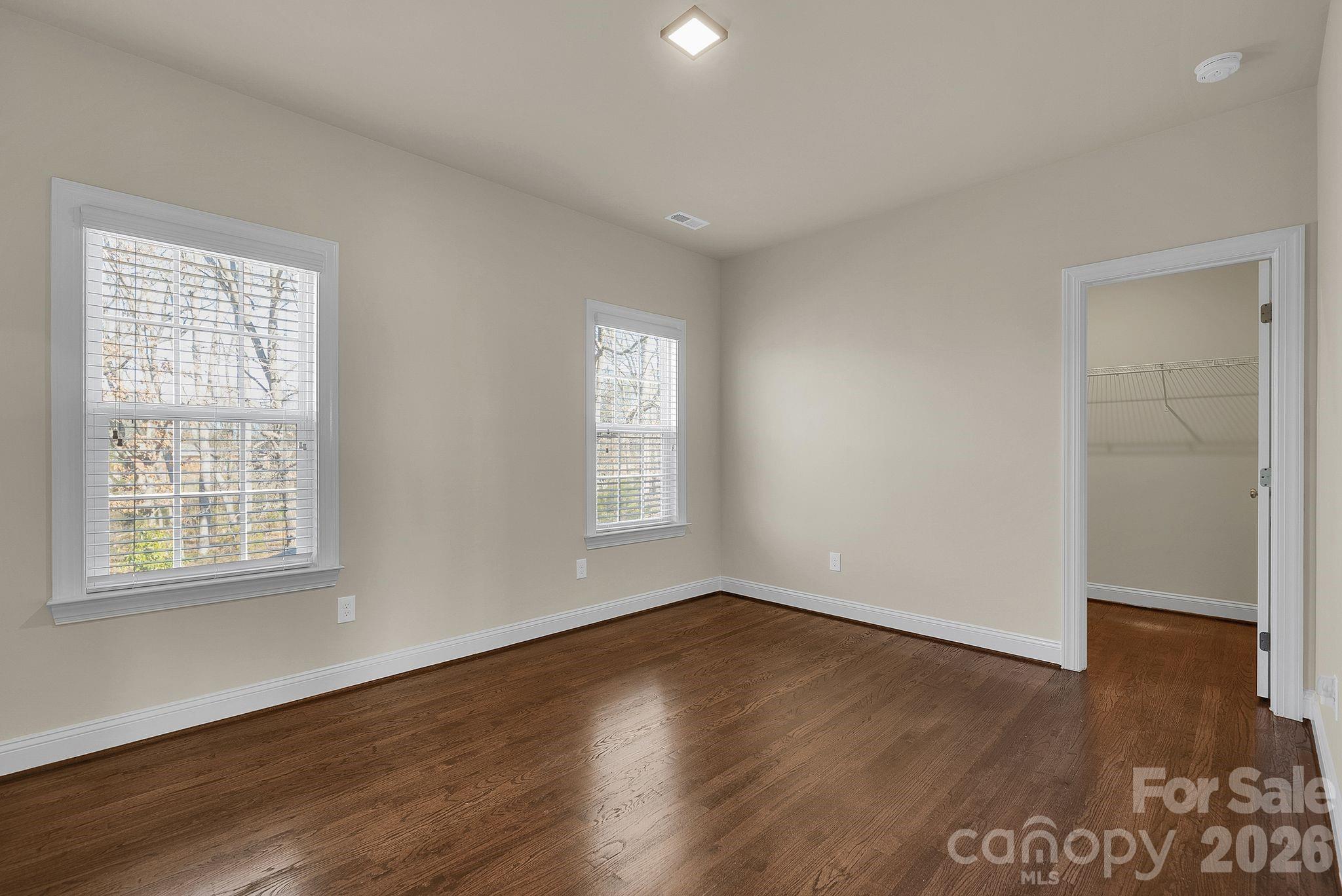 535 Brightleaf Place Northwest Concord, NC 28027 - Photo 31 of 48 an empty room with wooden floor and windows
