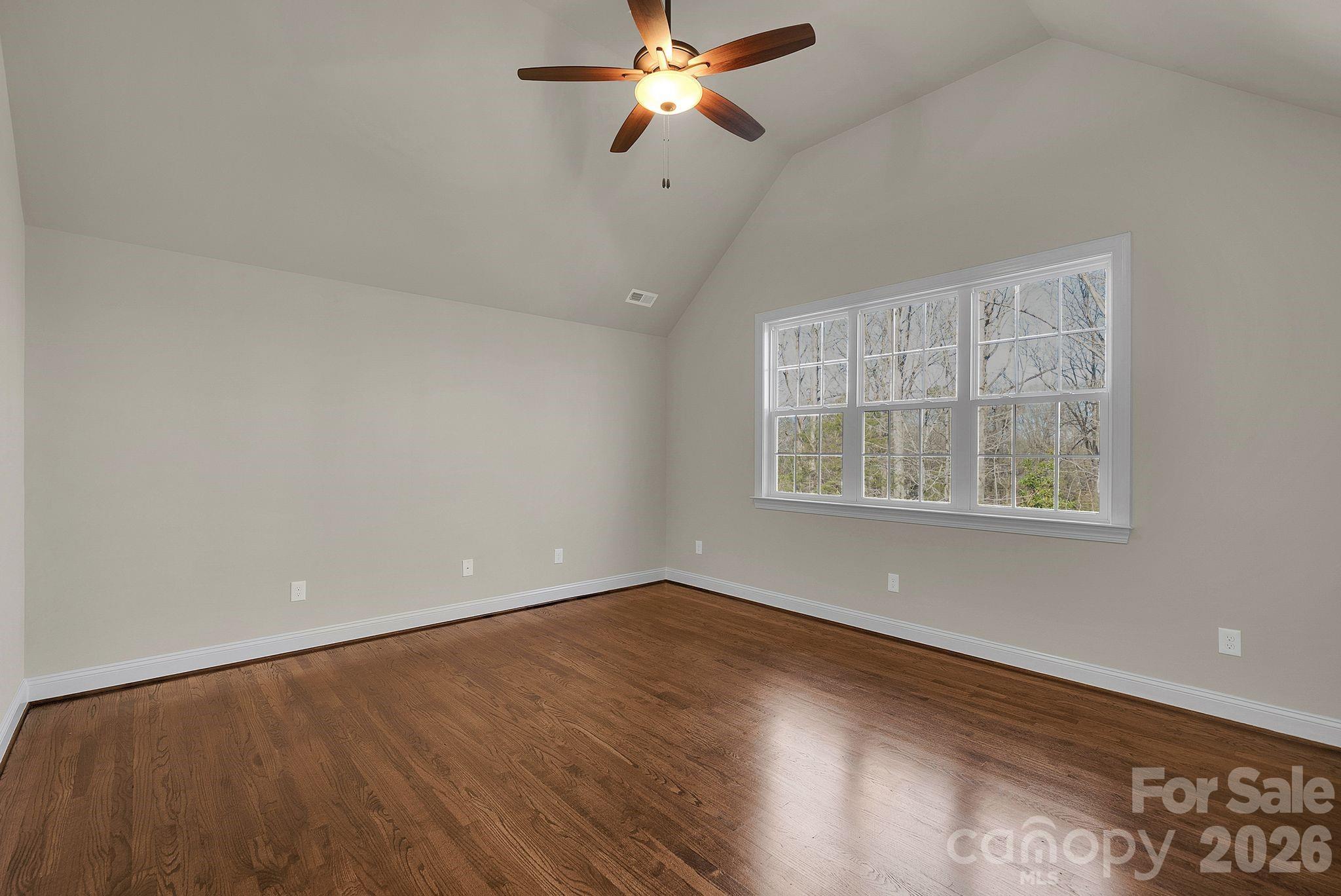 535 Brightleaf Place Northwest Concord, NC 28027 - Photo 32 of 48 an empty room with wooden floor ceiling fan and windows