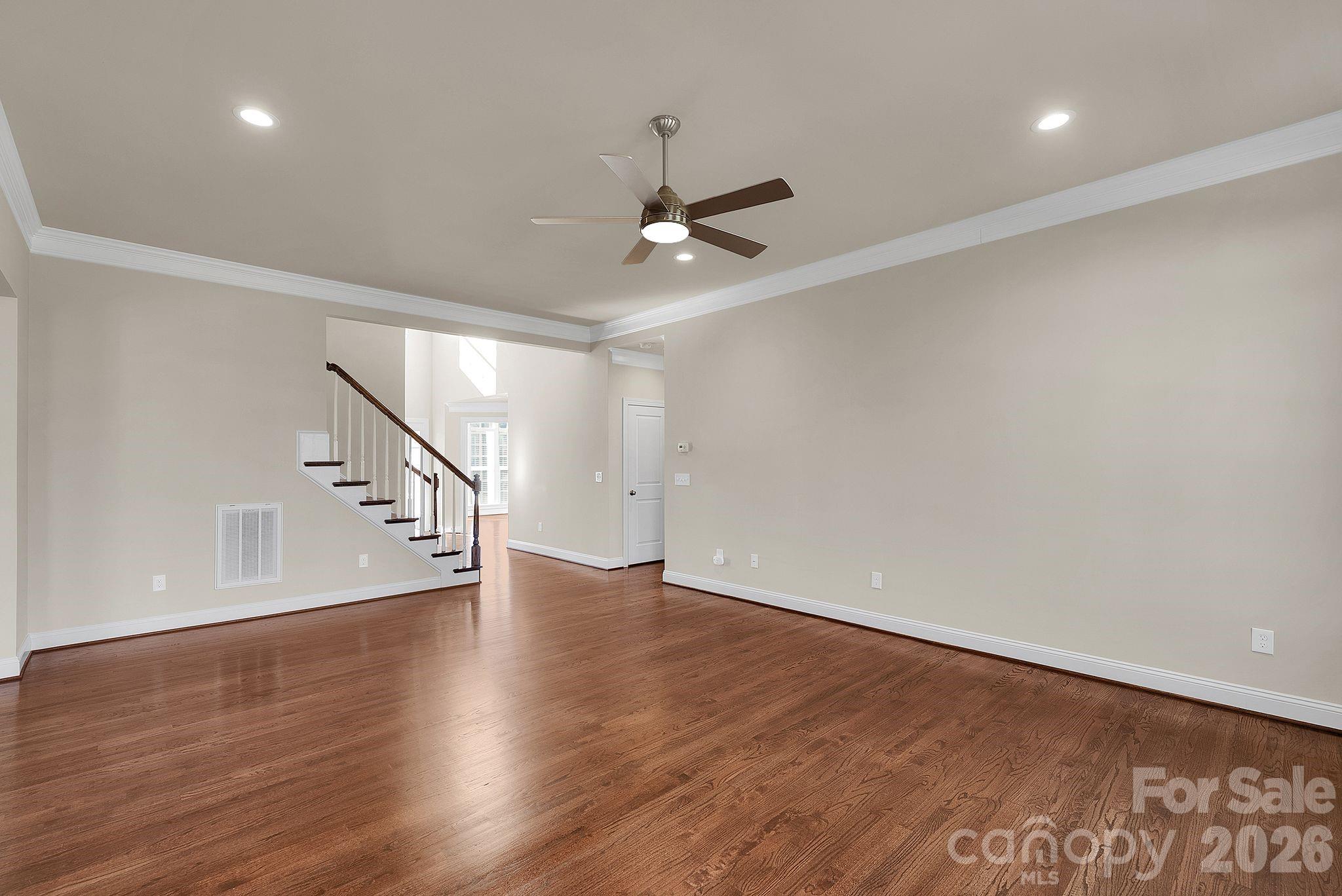 535 Brightleaf Place Northwest Concord, NC 28027 - Photo 10 of 48 a view of an empty room with wooden floor and a ceiling fan