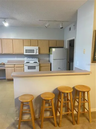 a kitchen with stainless steel appliances a table and chairs in it
