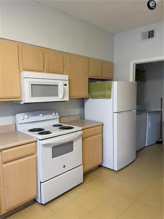 a kitchen with a stove refrigerator and microwave