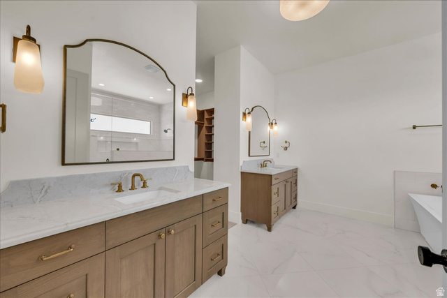 1620 Belayer Drive St. George, UT 84770 - Photo 23 of 51 Spacious bathroom featuring dual wood-finish vanity cabinets with stone countertops, a freestanding tub, and large format floor tiling