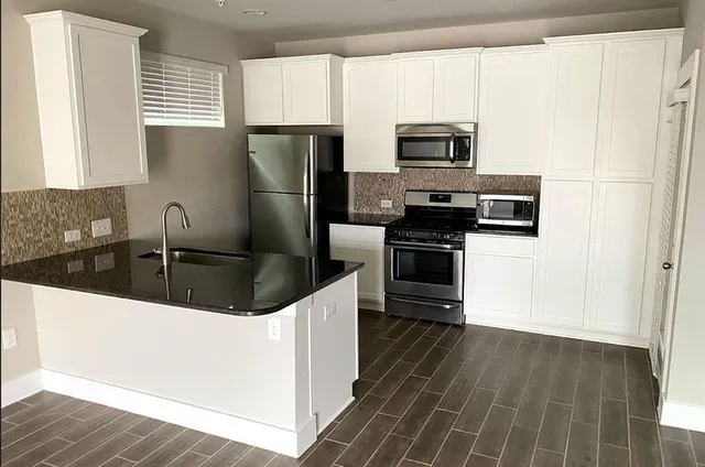 a kitchen with stainless steel appliances a refrigerator a stove a microwave and cabinets