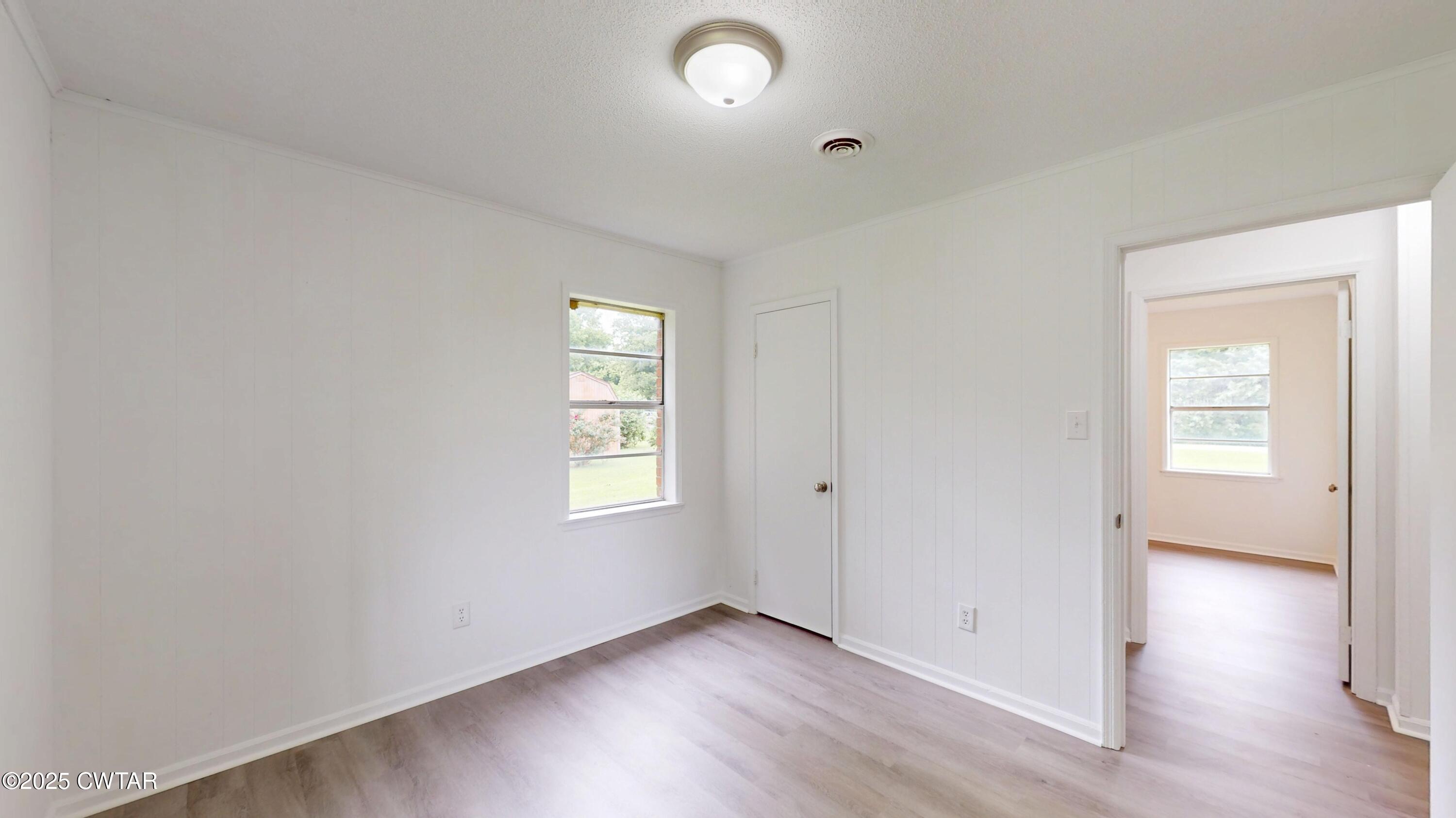 245 Smithville Road Ripley, TN 38063 - Photo 24 of 34 an empty room with wooden floor and windows
