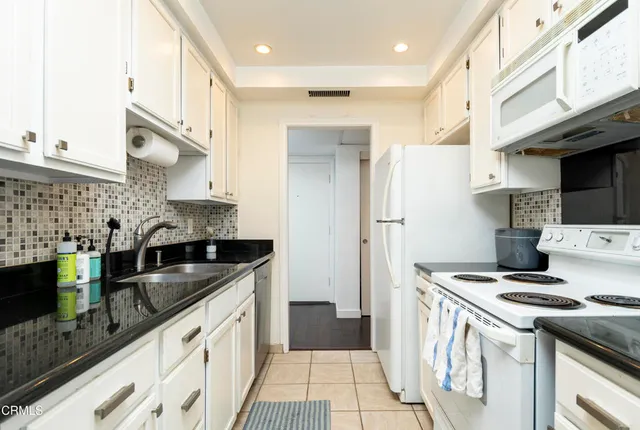a kitchen with stainless steel appliances granite countertop a sink a stove and a refrigerator