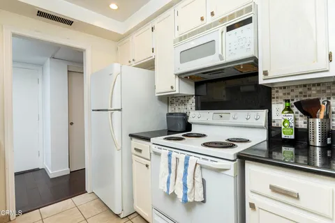 a kitchen with appliances a sink and cabinets