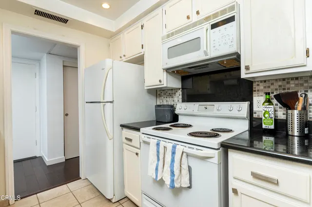 a kitchen with appliances a sink and cabinets
