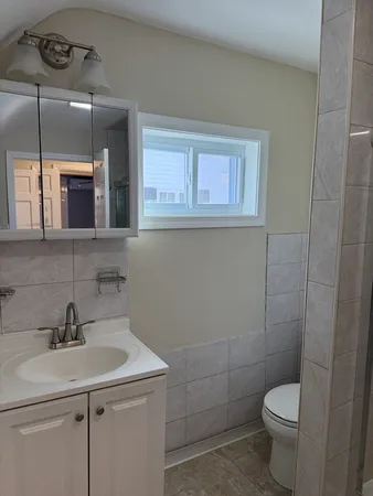 a bathroom with a toilet sink and mirror