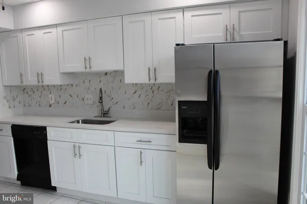 a kitchen with a white cabinets and refrigerator