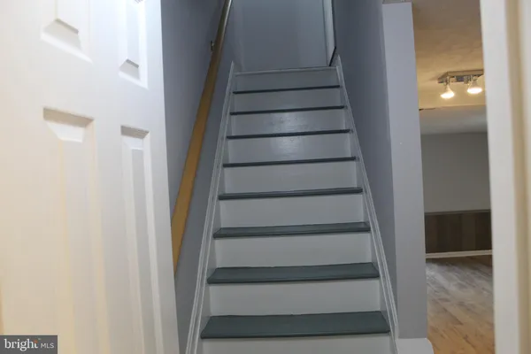 a view of a hallway with wooden floor and staircase
