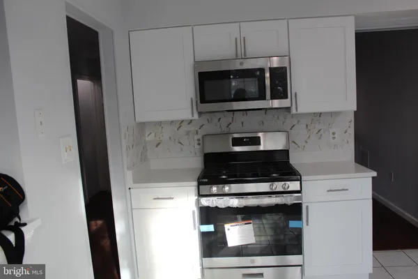 a kitchen with stainless steel appliances a stove microwave and sink