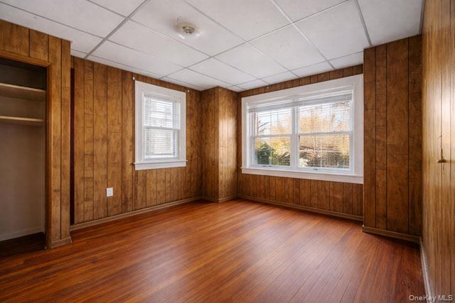 88-02 88th Street Queens, NY 11421 - Photo 12 of 16 an empty room with wooden floor and windows