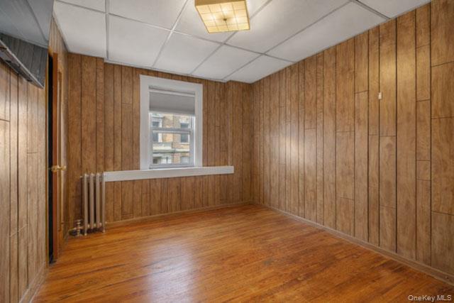 88-02 88th Street Queens, NY 11421 - Photo 6 of 16 a view of an empty room with wooden floor and a window