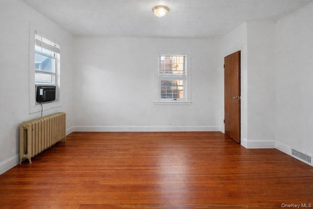 88-02 88th Street Queens, NY 11421 - Photo 10 of 16 a view of an empty room with wooden floor and a window