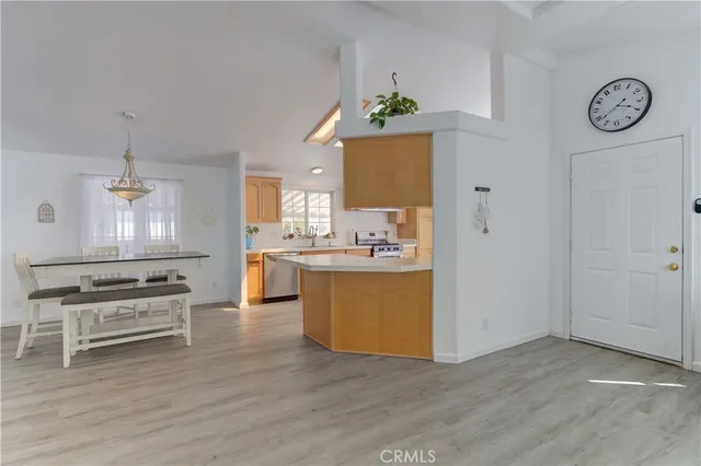a view of a kitchen with kitchen island a counter top space a sink stainless steel appliances and cabinets