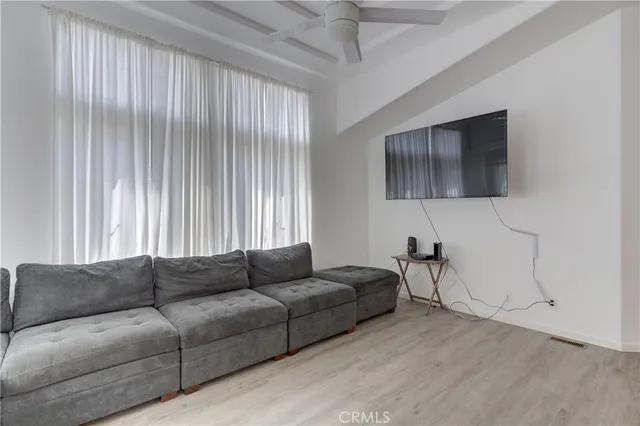 a living room with furniture a dining table and a wooden floor