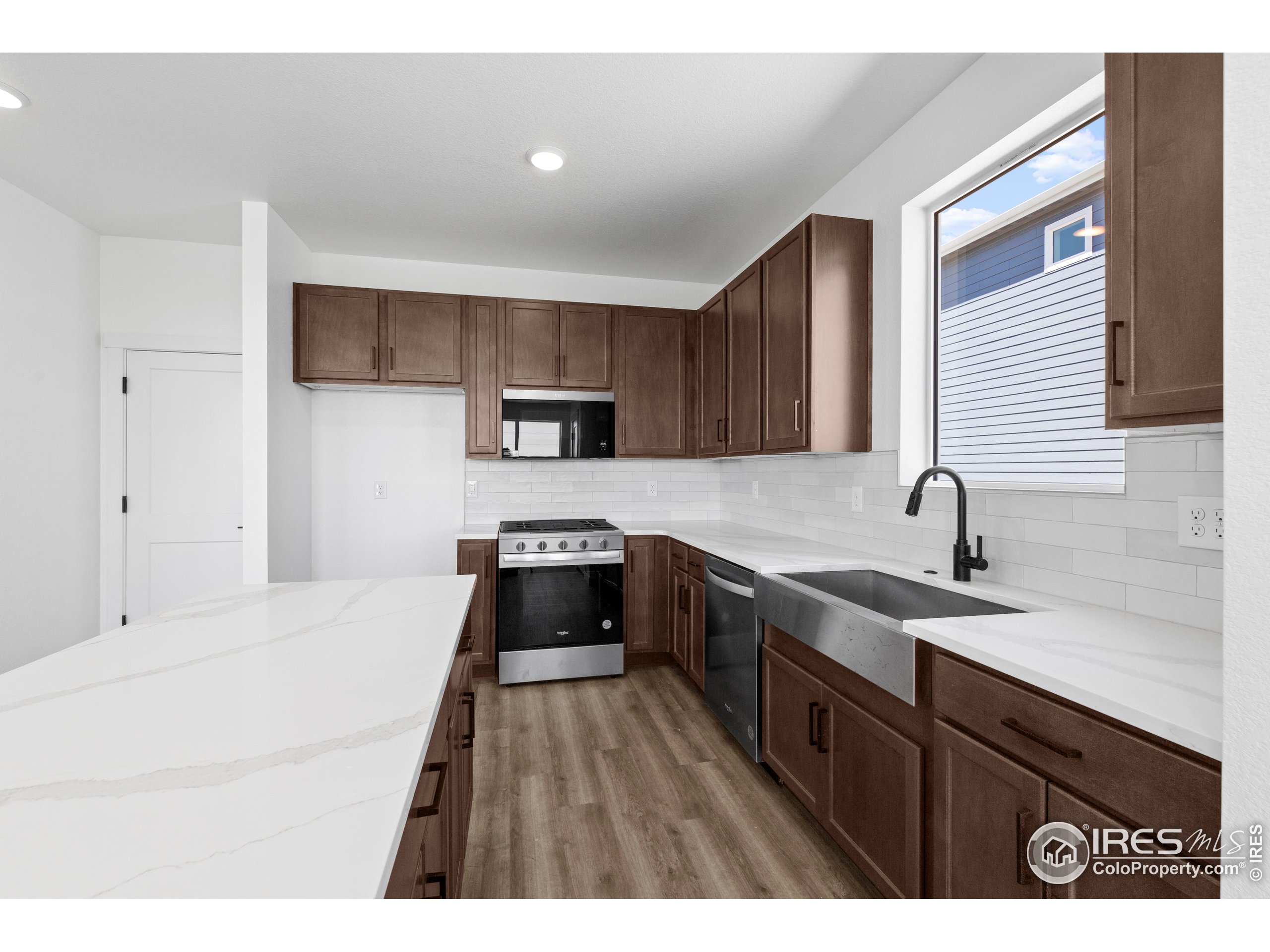 737 Muturu Road Johnstown, CO 80534 - Photo 14 of 26 a kitchen with stainless steel appliances granite countertop a sink stove and refrigerator