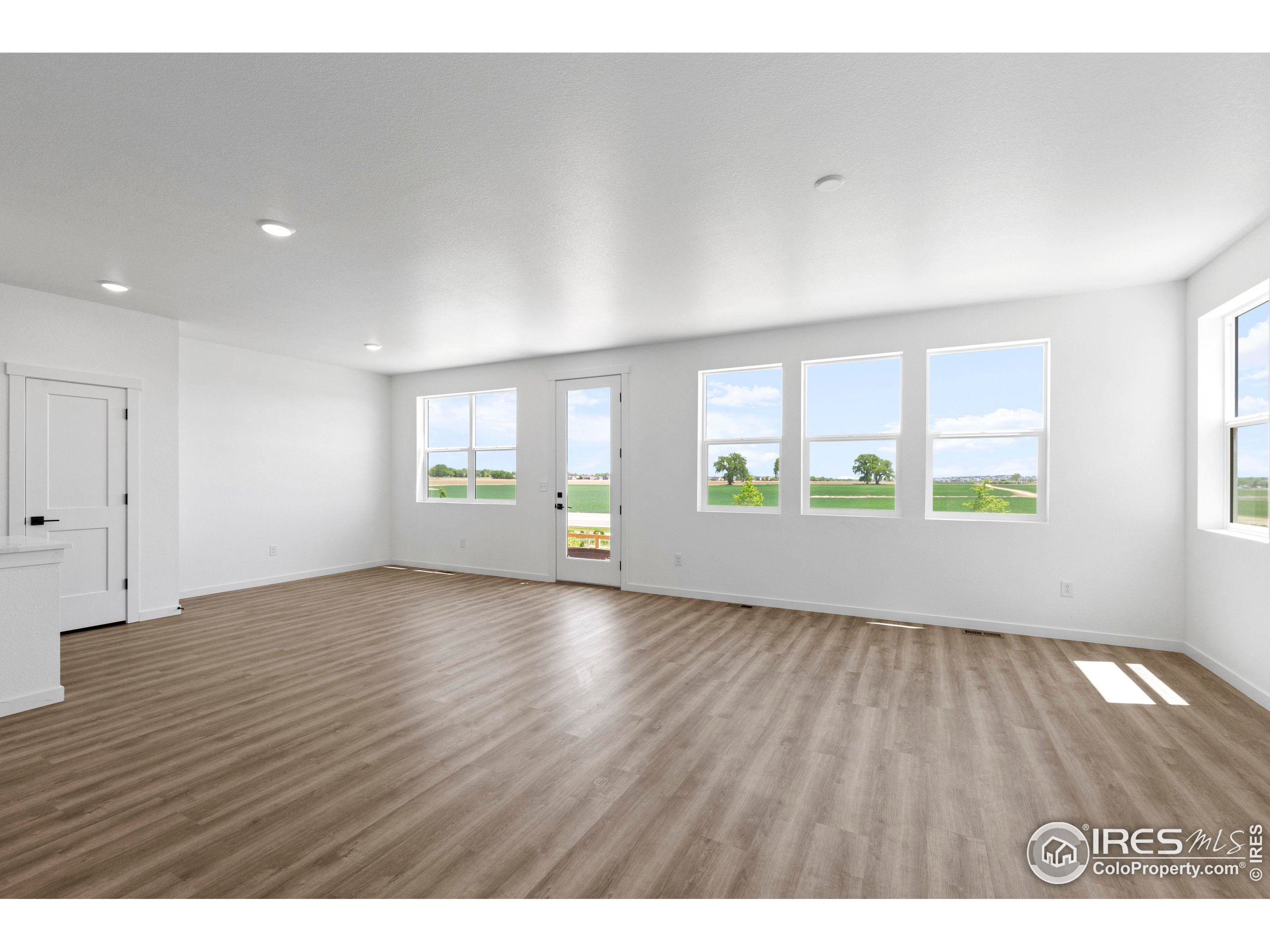 737 Muturu Road Johnstown, CO 80534 - Photo 8 of 26 a view of an empty room with a window and wooden floor