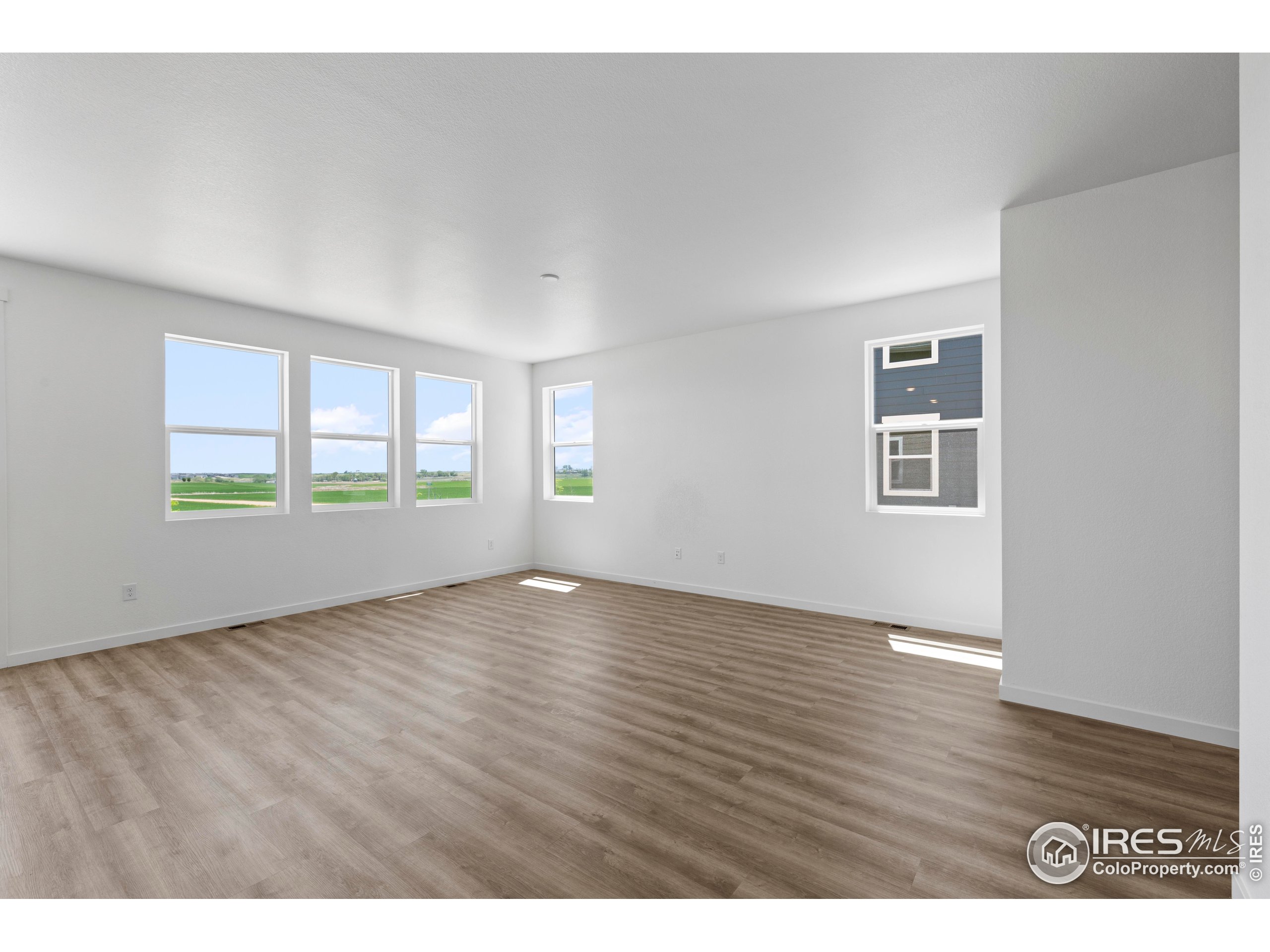 737 Muturu Road Johnstown, CO 80534 - Photo 9 of 26 a view of an empty room with a window and wooden floor