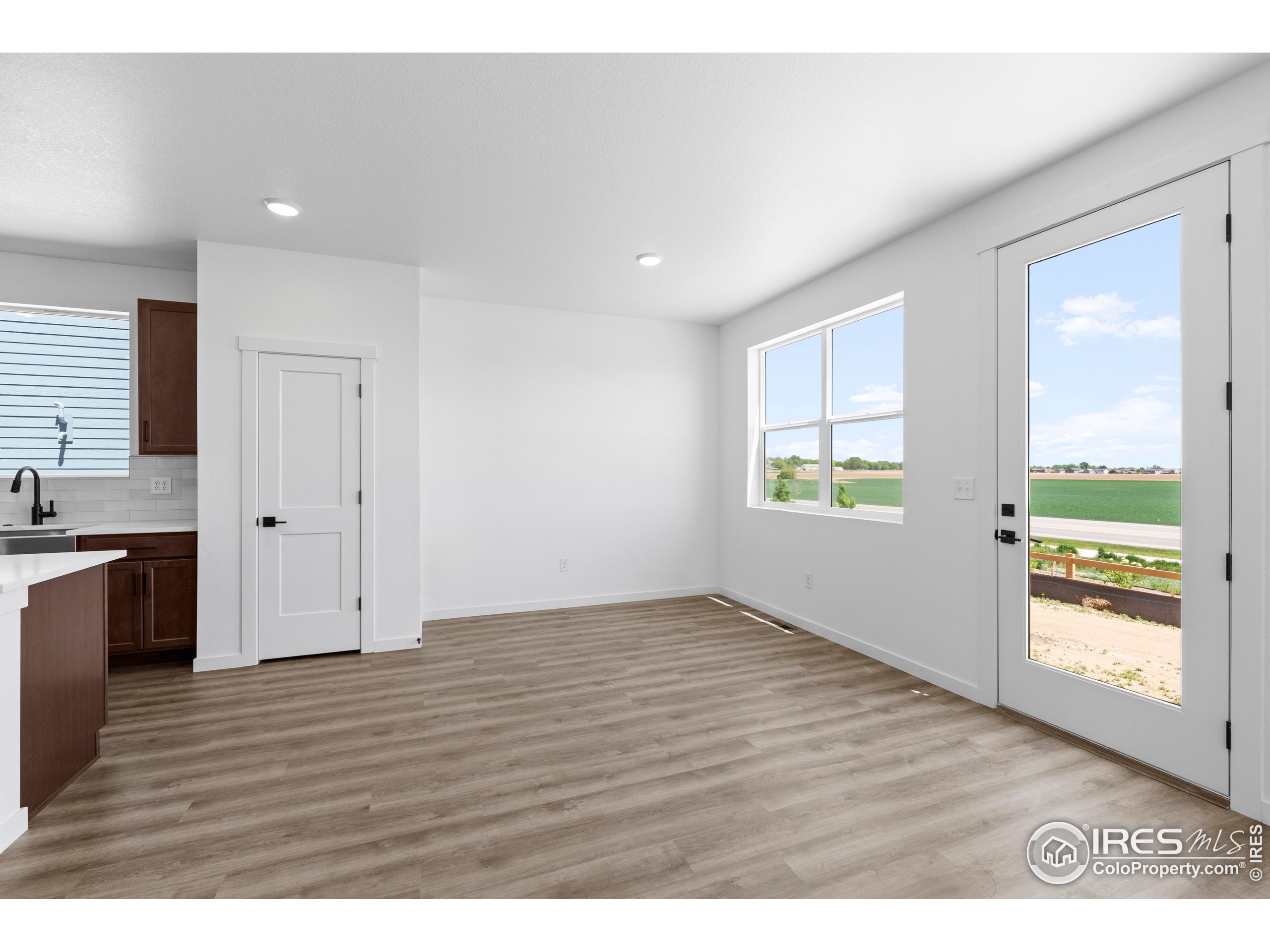 737 Muturu Road Johnstown, CO 80534 - Photo 10 of 26 a view of an empty room with a window and wooden floor