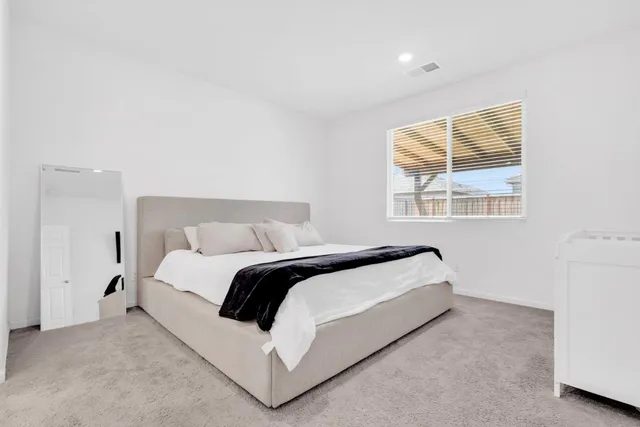 a bed sitting in a bedroom next to a window