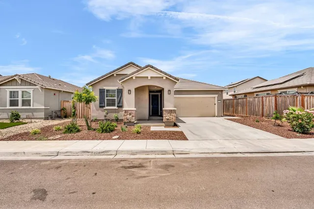 a front view of a house with a garden and yard