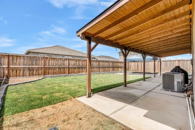 a view of a backyard with wooden fence and a floor to ceiling window