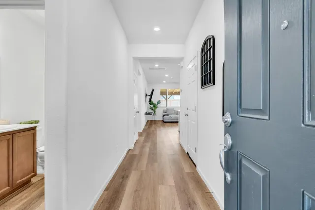 a view of a hallway with wooden floor and staircase