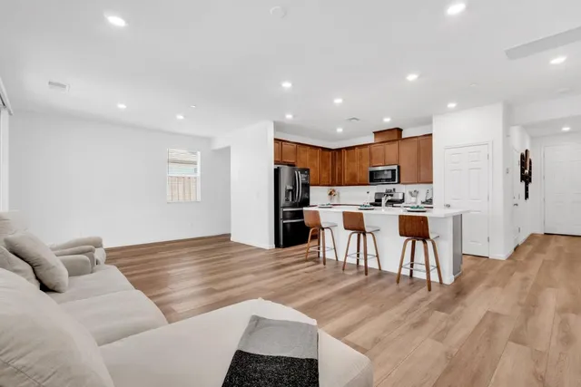 a living room with stainless steel appliances kitchen island furniture and a kitchen view