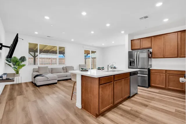 a large living room with stainless steel appliances granite countertop a couch and a view of living room