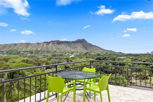 a view of a city from a balcony with chairs