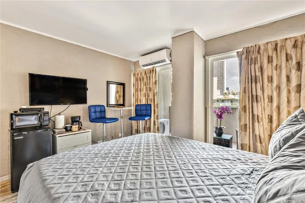 a bedroom with a bed and a flat tv screen on dresser