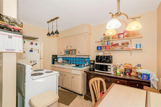 a kitchen with a refrigerator a stove and wooden floor
