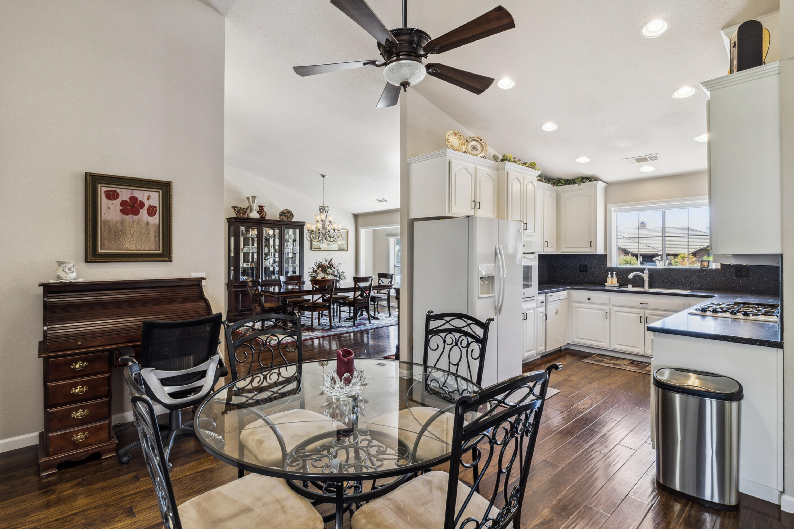 3884 Andes Drive Redding, CA 96001 - Photo 12 of 56 a kitchen with stainless steel appliances kitchen island granite countertop a refrigerator a stove a sink a dining table and chairs with wooden floor