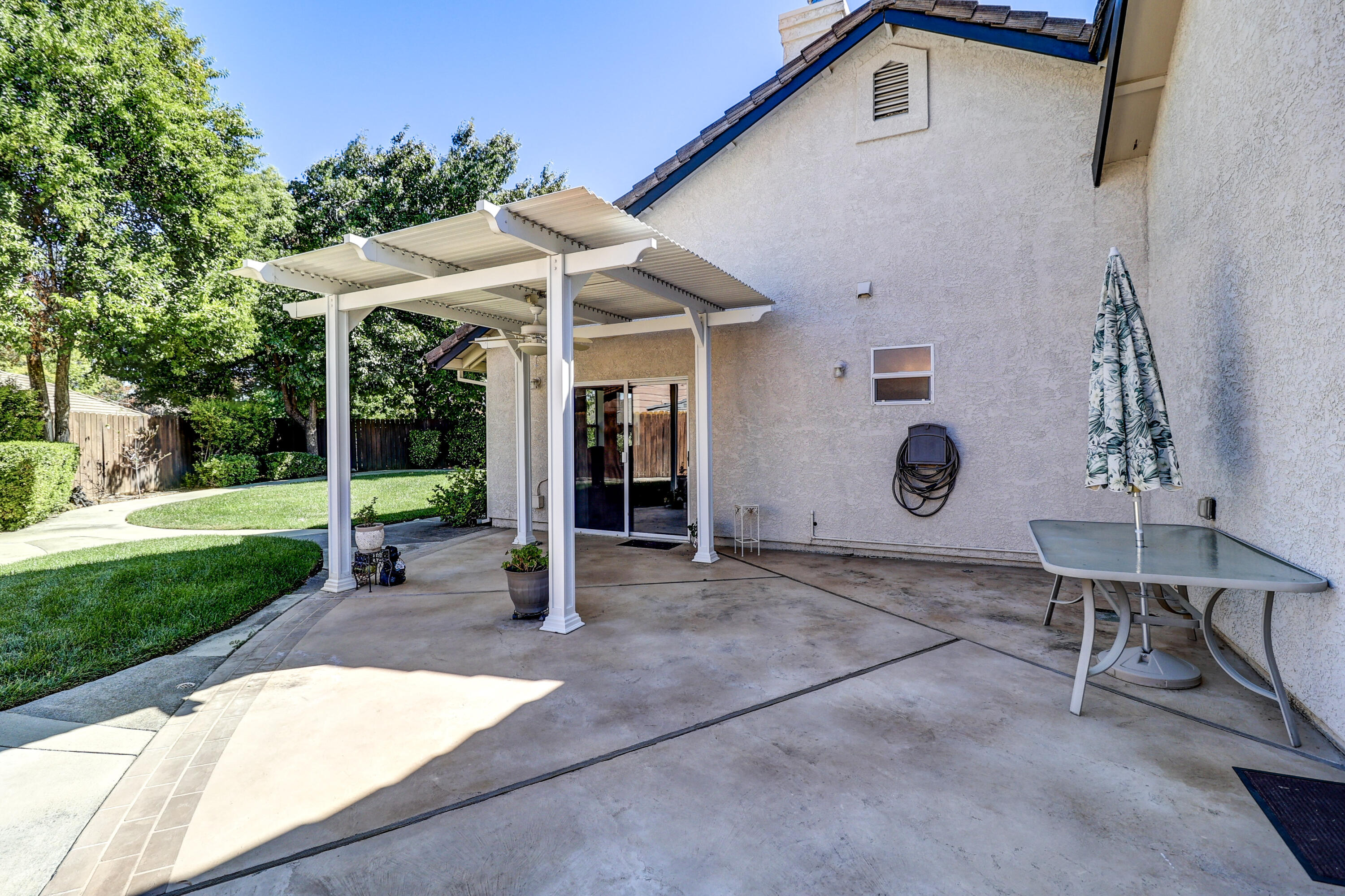 3884 Andes Drive Redding, CA 96001 - Photo 37 of 56 a view of a patio with a table and chairs under an umbrella