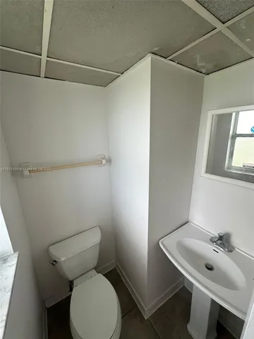 a bathroom with a sink mirror and toilet
