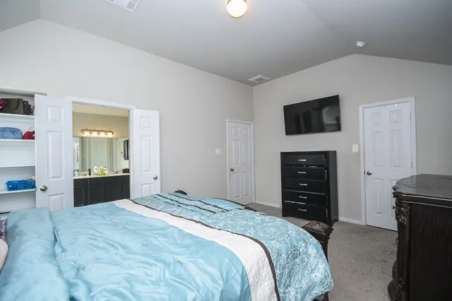 a bedroom with a bed and a flat screen tv