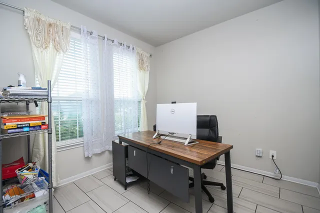 a view of a workspace with furniture and a window