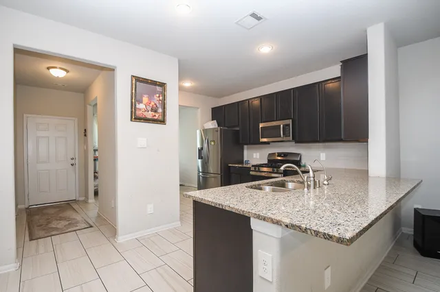 a kitchen with granite countertop a sink and a stove top oven