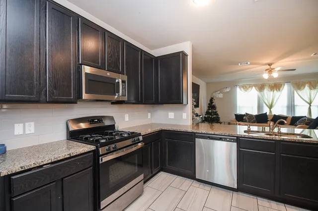 a kitchen with a sink and steel appliances