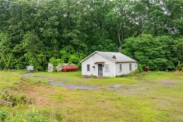 a view of a big house with a big yard and large trees